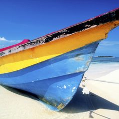 Yellow and blue boat on a sandy beach