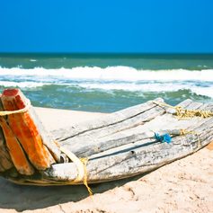 Primitive boat on the Indian beach made of wood tied with string