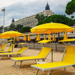 Yellow sun loungers and parasols on the beach outside the Carlton hotel in Cannes