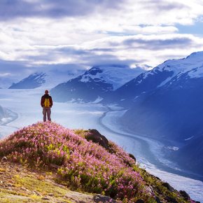 A charter guest standing on a mountain peak overlooking the view