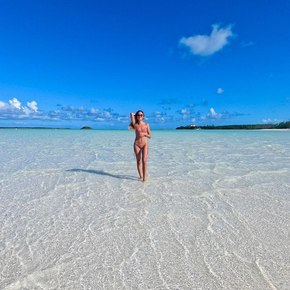 WOman in pink bikini standing in the shallow waters 