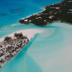 View from above of Moriah Harbour Cay's turquoise waters and surrounding shoreline covered in vegetation 