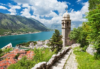 stunning coastline of Montenegro with old tower, red-roofed houses and forest-covered mountains