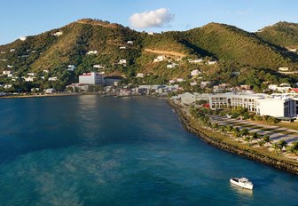 A single yacht cruising close to the coast of a British Virgin Island