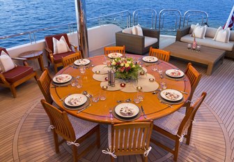 circular dining table on the upper deck aft of charter yacht Far From It 