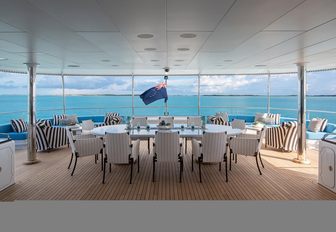 Alfresco dining arrangement onboard charter yacht ETERNITY with long table and white seats