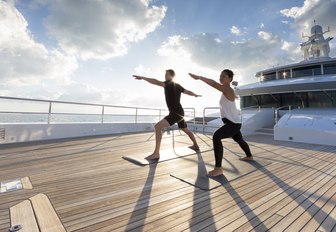 charter guests do yoga on the foredeck aboard motor yacht NAUTILUS 