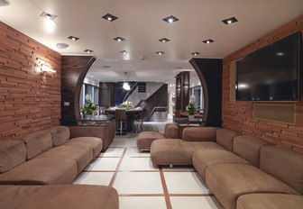 Superyacht One Blue main salon, with brown sofas and wood panelled walls