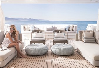 charter guest relaxes on the main deck aft with its sheer curtains on board charter yacht TURQUOISE 