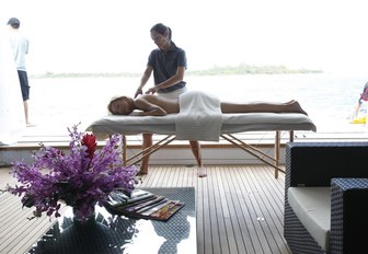 charter guest enjoys a massage in the beach club aboard luxury yacht SOVEREIGN 