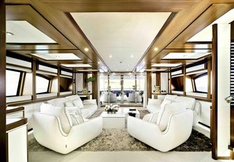 luxury yacht bunker main salon with white sofas and view of exterior dining 