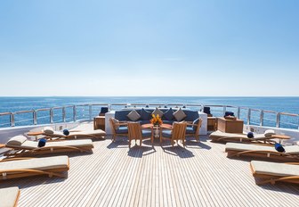 seating area and sun loungers line up on the sundeck of charter yacht WHEELS