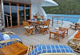 table, chairs and lounging areas on the upper deck aft of charter yacht M4