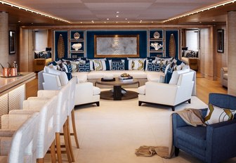 bar and armchair with white sofas beyond in the main salon of luxury yacht Cloud 9