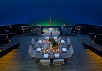 table on upper deck aft set up for evening meal on board superyacht ‘Ocean Emerald’ 