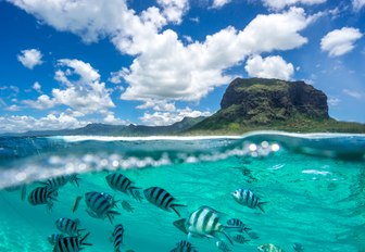 Beautiful mountain and clouds from the Indian Ocean. The lower part of the picture showing the underwater world with fishes