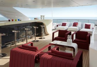 The sophisticated sun deck of charter yacht HOME with cocktail bar and lounging seats overlooking the ocean f