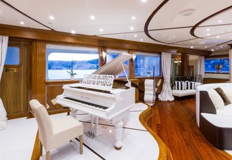 white grand piano in the main salon of charter yacht LEGEND