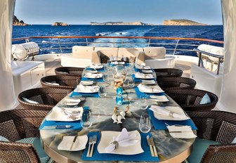 al fresco dining setup on the sundeck of charter yacht DENIKI 