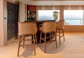 Superyacht charter QU2 interior wet bar with three stools