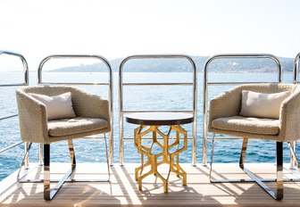 table and chairs on side balcony of luxury yacht BLUSH