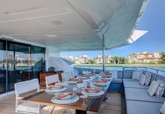 alfresco dining setup on the main deck aft of charter yacht Drew 