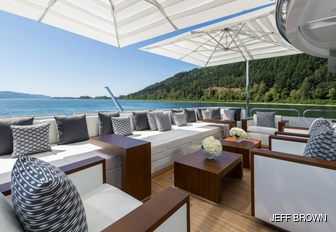 sundeck of luxury yacht chasseur, with seating area and parasols