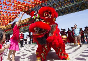 A small girl admires the colorful costumes at the festival in Penang