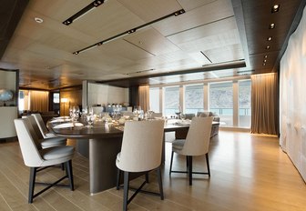 dining table flanked by full-length windows on board charter yacht CLOUDBREAK 