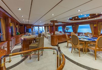 the luxurious and deluxe lounge with sophisticated seating and dining space as well as cocktail bar on charter yacht quintessa