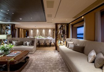 sofas and dining table beyond in the main salon aboard charter yacht VERTIGE