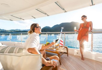 guests on board charter yacht King Baby in al fresco seating area drink champagne