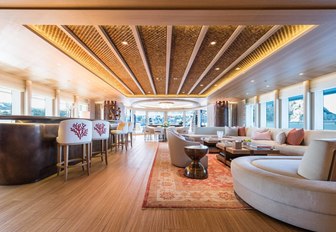 inviting salon with sumptuous seating and a bar on board charter yacht Here Comes The Sun