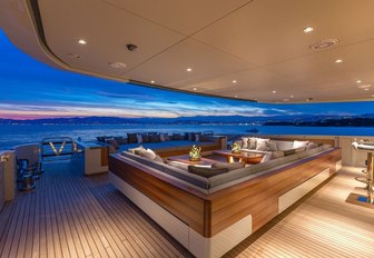 A nighttime shot of the sofa seating on the exterior of superyacht VERTIGE