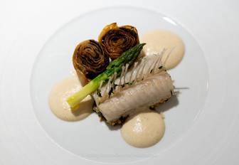 A plate of superyacht cuisine with a tip of asparagus on top