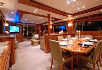 Interior shot of the superyacht Annabel II, with formal dining and seating area with TV