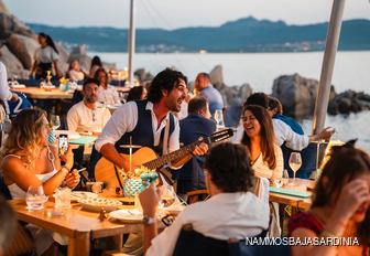 Musicians playing around tables at Nammos Baja Sardinia