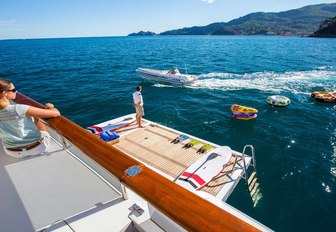 guest aboard motor yacht DIANE looks on at fold-down swim platform and water toys in the sea