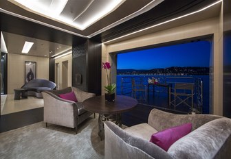 luxe seating area opens onto terrace on board charter yacht Mogambo