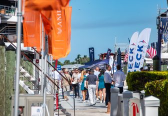 Fort Lauderdale International Boat Show (FLIBS) visitors walking along docks between flags