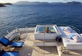 superyacht jacuzzi with charter guest lying back enjoying the sun