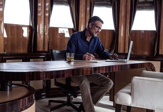 charter guest catches up on business in private master suite office aboard superyacht MEAMINA 