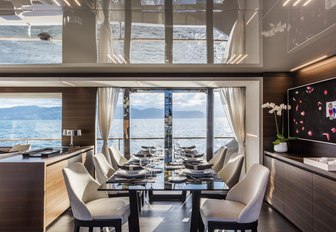 formal dining area flanked by floor-to-ceiling windows on board charter yacht December Six