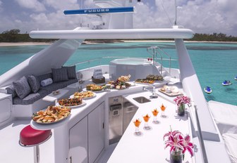 Sun deck with bar and jacuzzi and seating on board charter yacht At Last