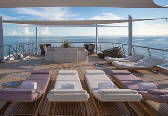 Sun deck with loungers and sofa on board superyacht DREAM, complete with views over the sea