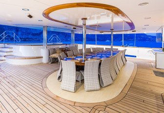 alfresco dining table next to pool on the aft deck of charter yacht LEGEND