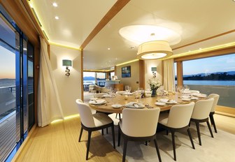 formal dining area flanked by large windows in the main salon of motor yacht SOLIS 