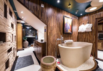 A stone bath tub situated amidst light brown decoration