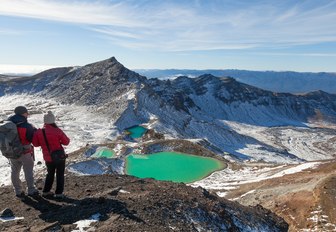 hikers take in lake on the Tongariro Crossing in Tongariro National Park, New Zealand