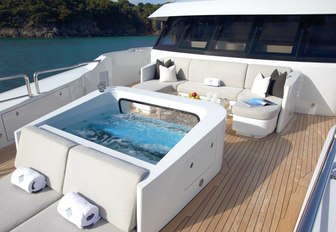 'moon pool', seating area and sun pads on the Portuguese bridge aboard motor yacht Muchos Mas